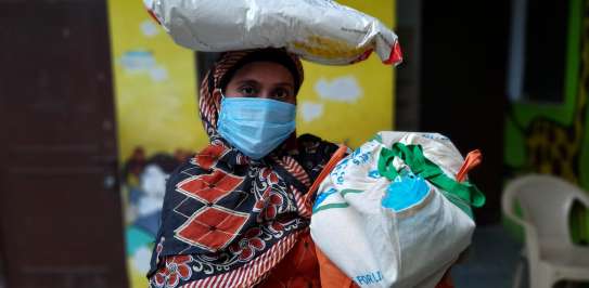 Woman receives essential food supplies for her family. 