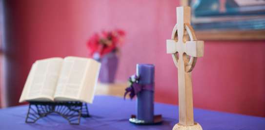 An altar with bible, candle and a crucifix