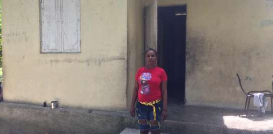 Vilia Marie Odinot, 49, stands in front of her disaster resistant home in Torbeck, South Haiti.