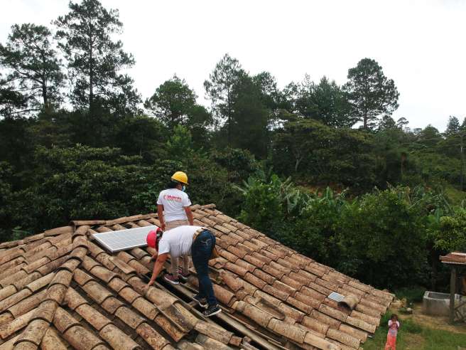 Marlen and her colleague installing solar panels