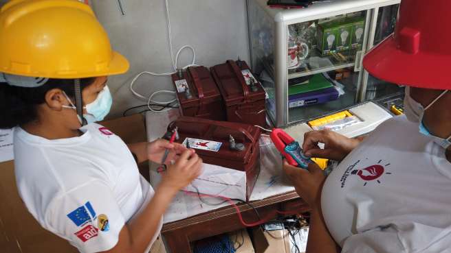 Marlen and her colleague from their business testing batteries