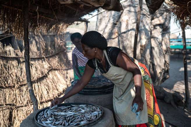 Tikambenji smokes the fish to preserve it before taking it to market. 