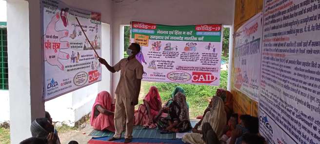 Mr Anil Kumar teaches a group of migrant labourers 