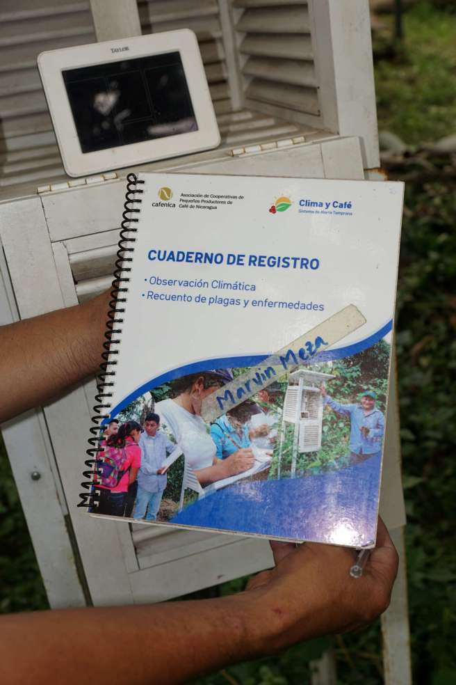 One of the climate observers proudly showing his log book which he uses to log the climate information captured through the climate station. 