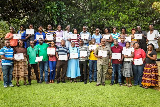 Farmers stand with their certificates for gender and equality training in Zambia, which was led by Sheila Murimoga from Christian Aid