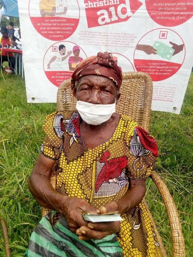 Marie 68, holding the cash she received as part of Christian Aid and World Food Programme’s cash distribution response.