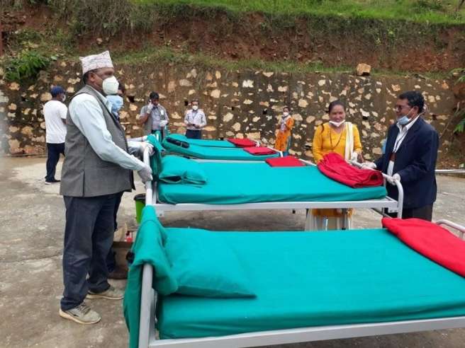 Hem Raj Chatkuli working with the town’s chairperson, Chandra Prasad Silwal to move the beds.