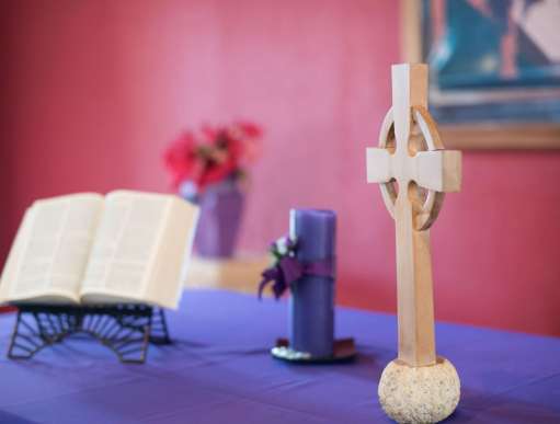 An altar with bible, candle and a crucifix