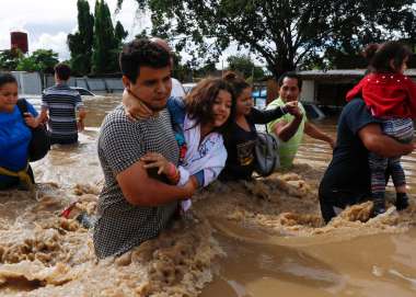 Family in Nicaragua wade through flood water after Hurricane Iota 