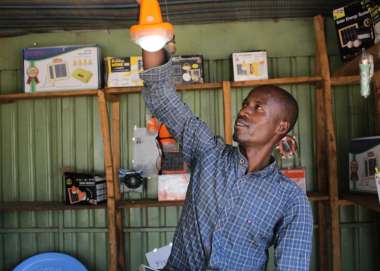 Robisha Tamiru in his solar shop in Konso Town, showing how the solar power lamps that he sells work.