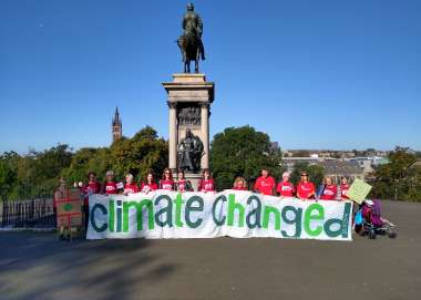 People standing in Glasgow with a banner that reads 'climate changed'