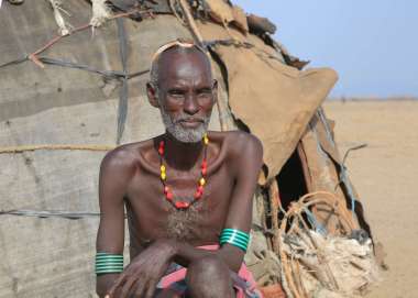 An elder black man sits in front of his makeshift tent in Dasenech, South Omo, Ethiopia