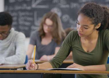 Sixth form students writing notes in class